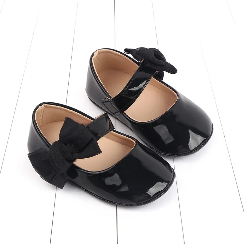 Acc. Zapatito charolado con moño lateral, suela engomado