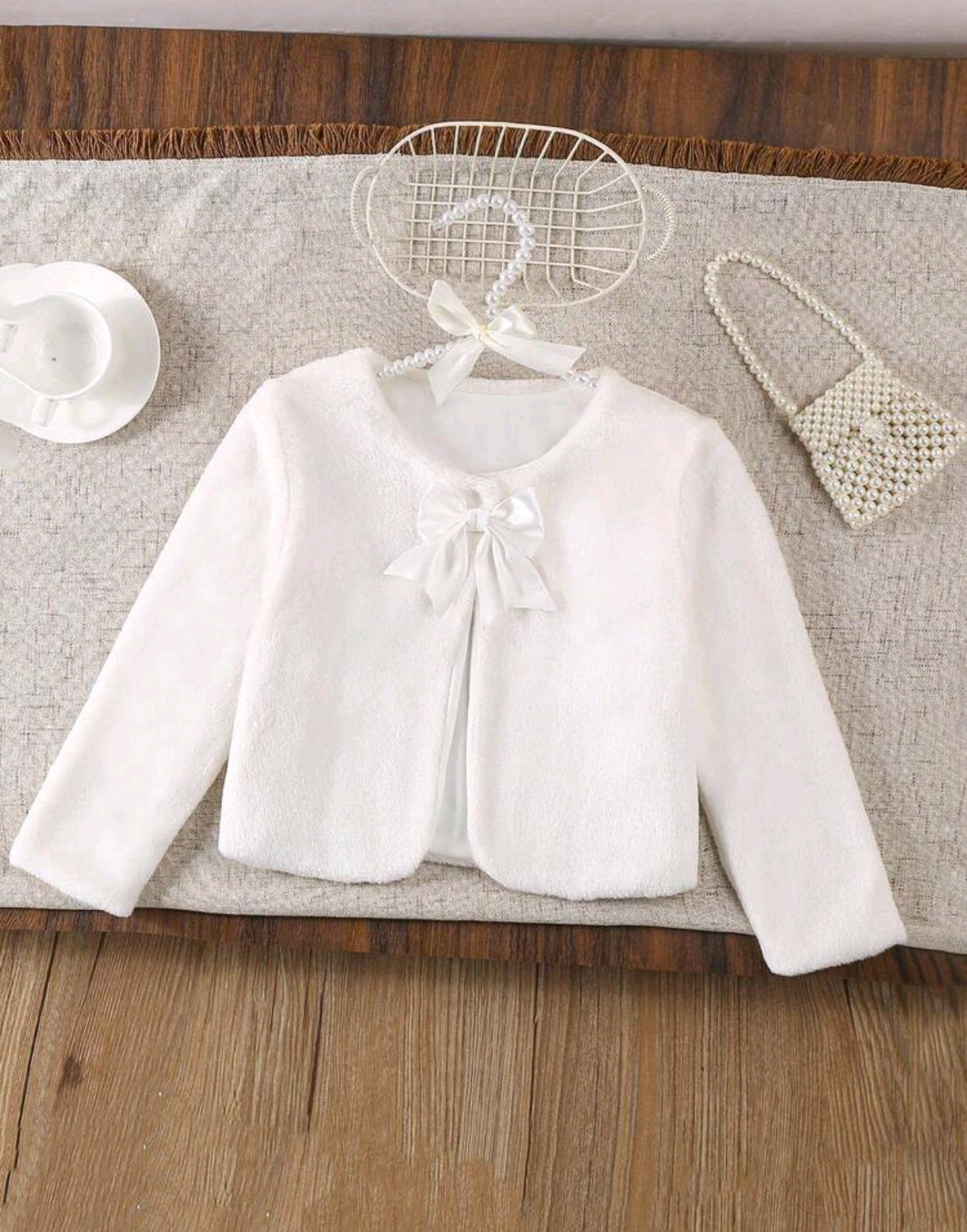 Abrigo blanco suave con detalle en moño