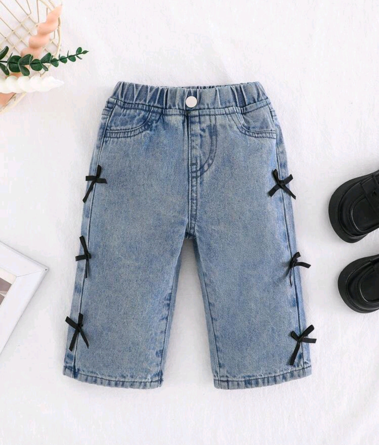 Pantalón de jeans para bebé con detalles en moños