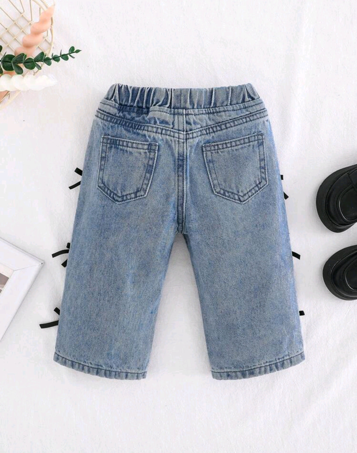 Pantalón de jeans para bebé con detalles en moños