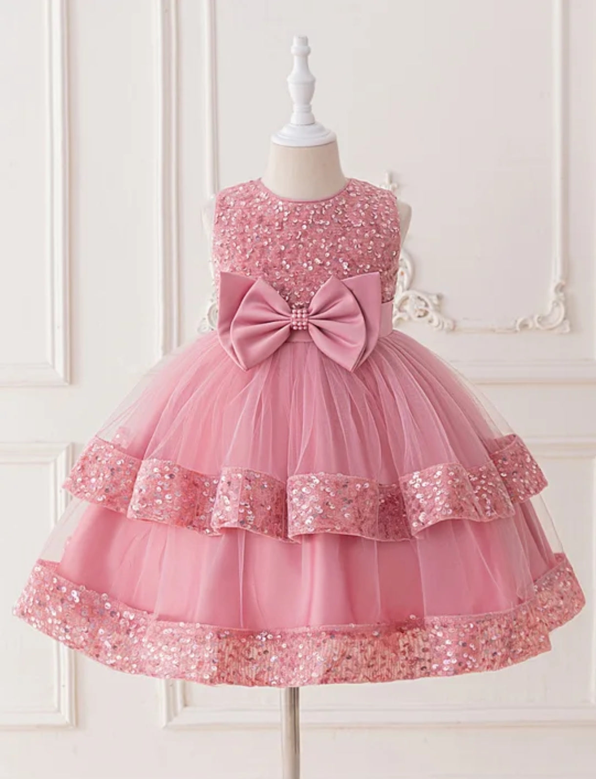 Vestido elegante con lentejuelas y moño frontal